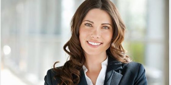 female with brunette hair and blue eyes smiling with whit teeth