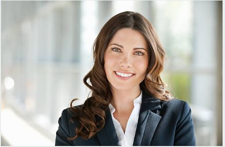 female with brunette hair and blue eyes smiling with whit teeth