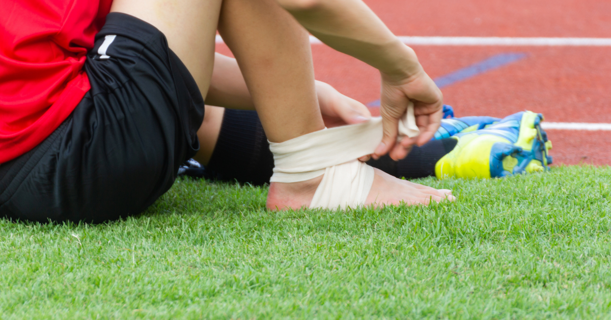 person in black shoes strapping foot with bandage