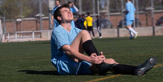 boy in blue soccer jersey injured on field