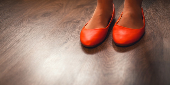 feet in red flats on wooden floor