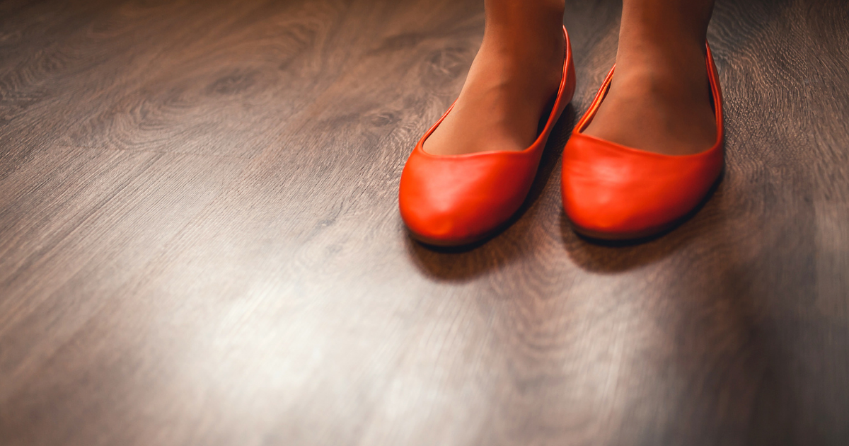 feet in red flats on wooden floor