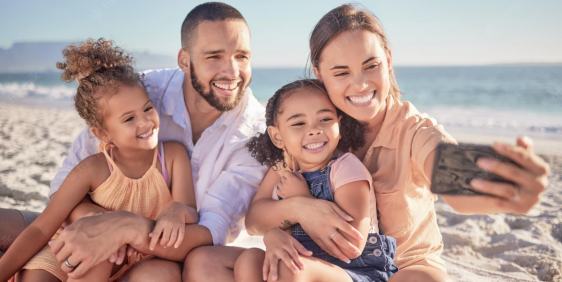 family with mum, dad and two daughters taking selfie with mobile phone